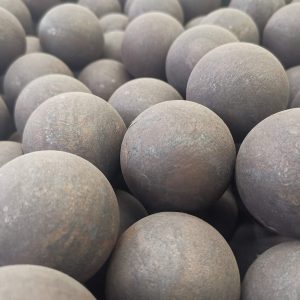 Close-up of forged steel grinding balls with rough surfaces, used in ball mills and SAG mills for industrial ore processing.