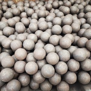 A large quantity of rolling steel grinding balls piled together, showcasing their spherical shape and uniform surface for use in ball mills.