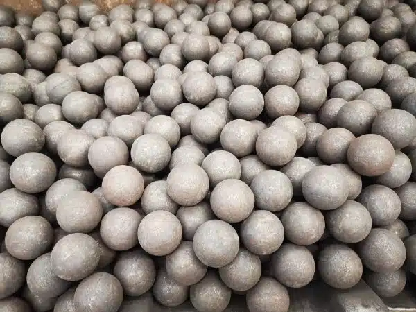 A large quantity of rolling steel grinding balls piled together, showcasing their spherical shape and uniform surface for use in ball mills.