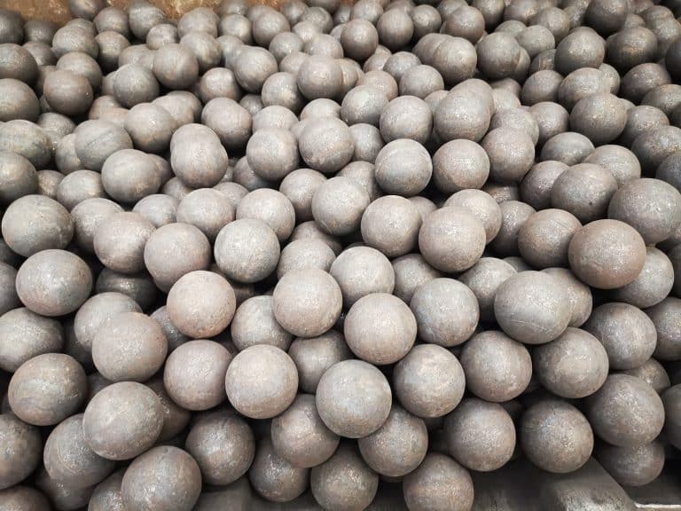 A large quantity of rolling steel grinding balls piled together, showcasing their spherical shape and uniform surface for use in ball mills.