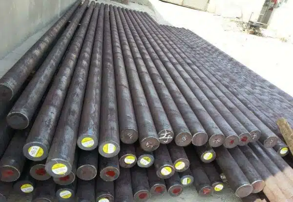 Neatly stacked steel grinding rods with labeled ends, ready for use in rod mills for ore processing.