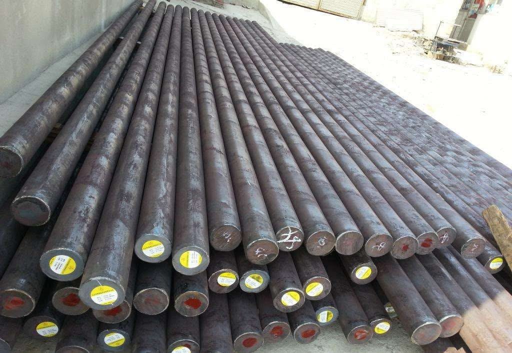 Neatly stacked steel grinding rods with labeled ends, ready for use in rod mills for ore processing.