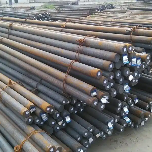 Bundles of steel grinding rods stacked in a storage yard, used in rod mills for grinding ores.