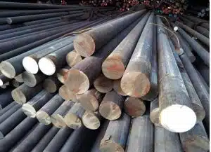 Steel grinding rods neatly stacked, used in industrial mills for crushing ores and other materials.