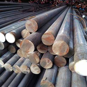 Steel grinding rods neatly stacked, used in industrial mills for crushing ores and other materials.