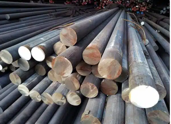 Steel grinding rods neatly stacked, used in industrial mills for crushing ores and other materials.