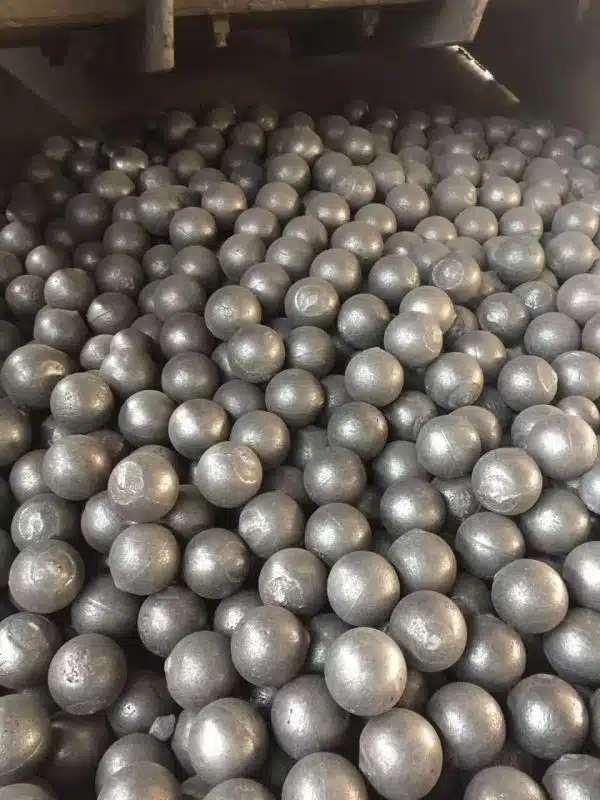A large batch of cast steel balls with smooth surfaces, used in mining and heavy industrial grinding.