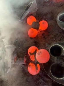 Molten steel balls glowing during the molding process, showing the high temperature of the casting.